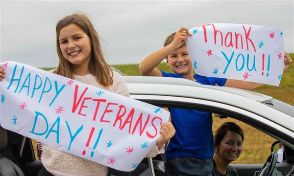 Girls holds signs to thank veterans
